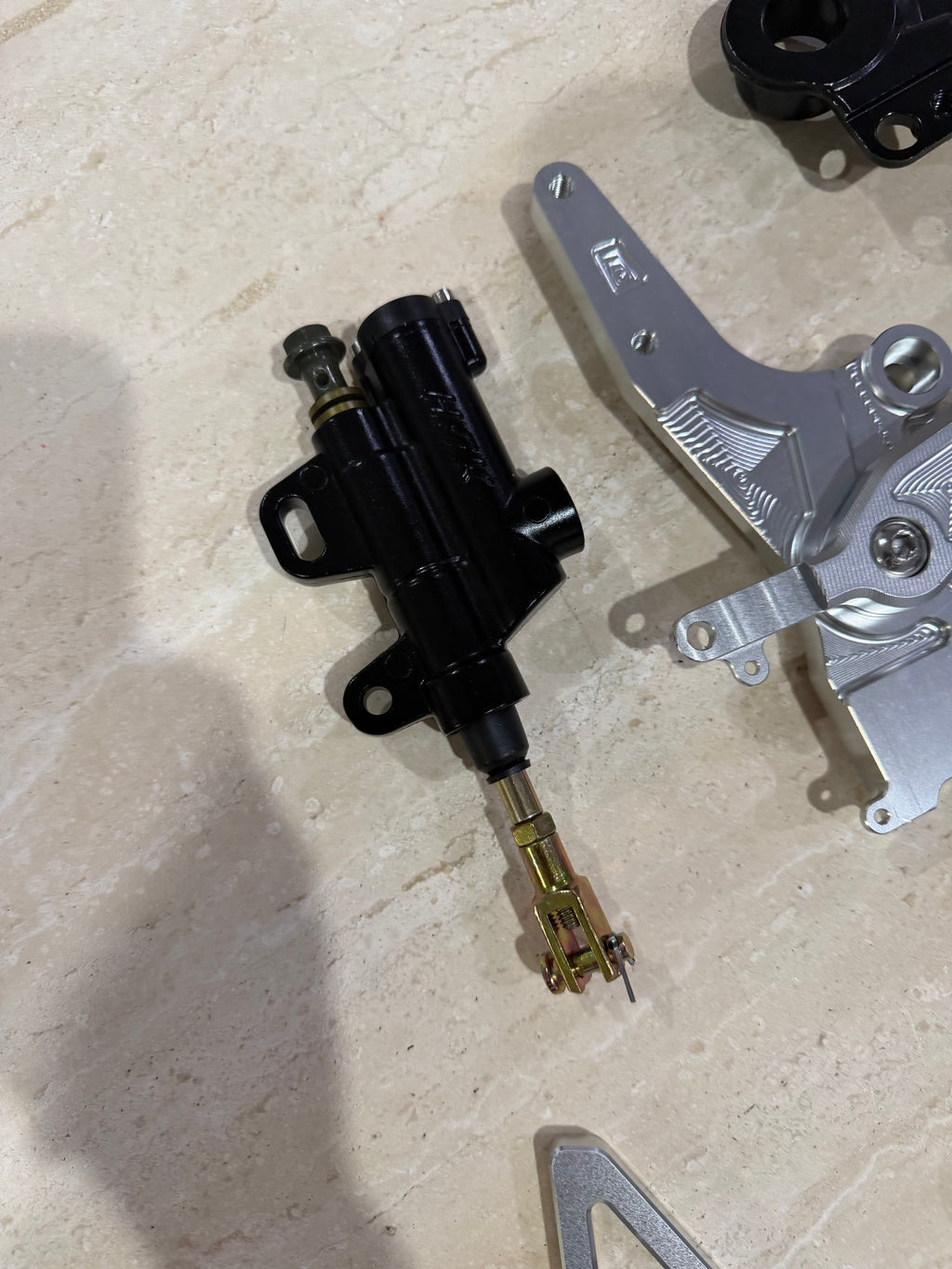 E-moto foot brake master cylinder and machined mounting bracket, close-up detail