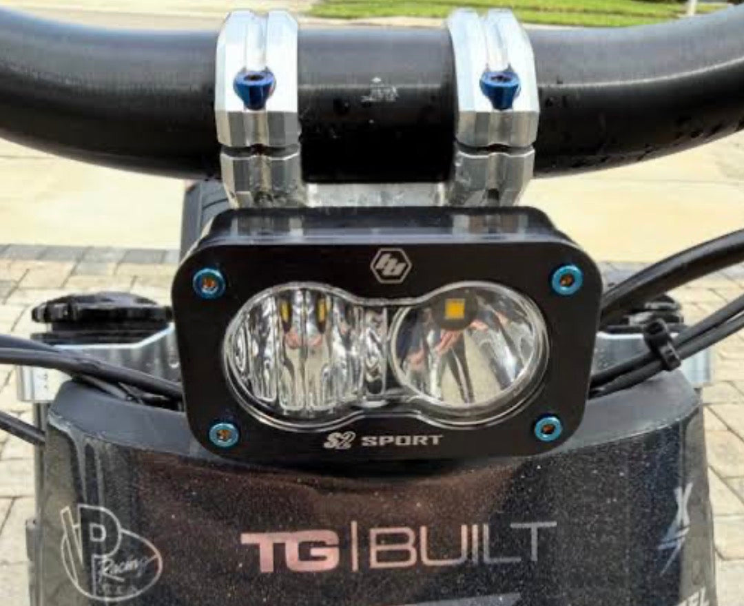 Baja Designs light fitted with a set of four blue titanium bolts on e-moto handlebars