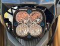 Baja Designs Squadron Pro light mounted with blue titanium bolts on an e-moto front plate
