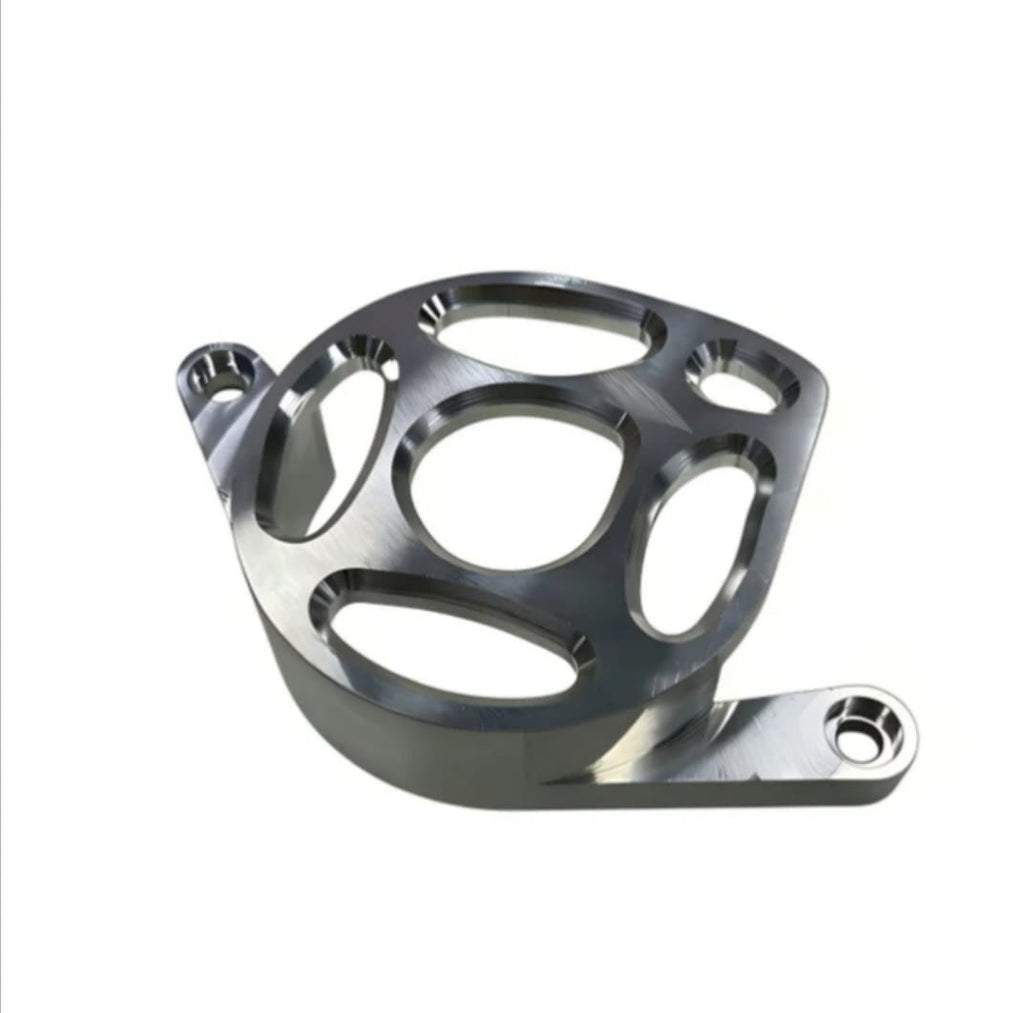 Metal motor cover for Surron LBX in gunmetal finish, angled view showing the mounting tabs