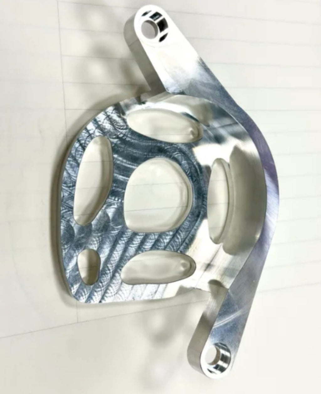 Metal motor cover for Surron LBX in burnt titanium blue finish, rear view showing the mounting arm