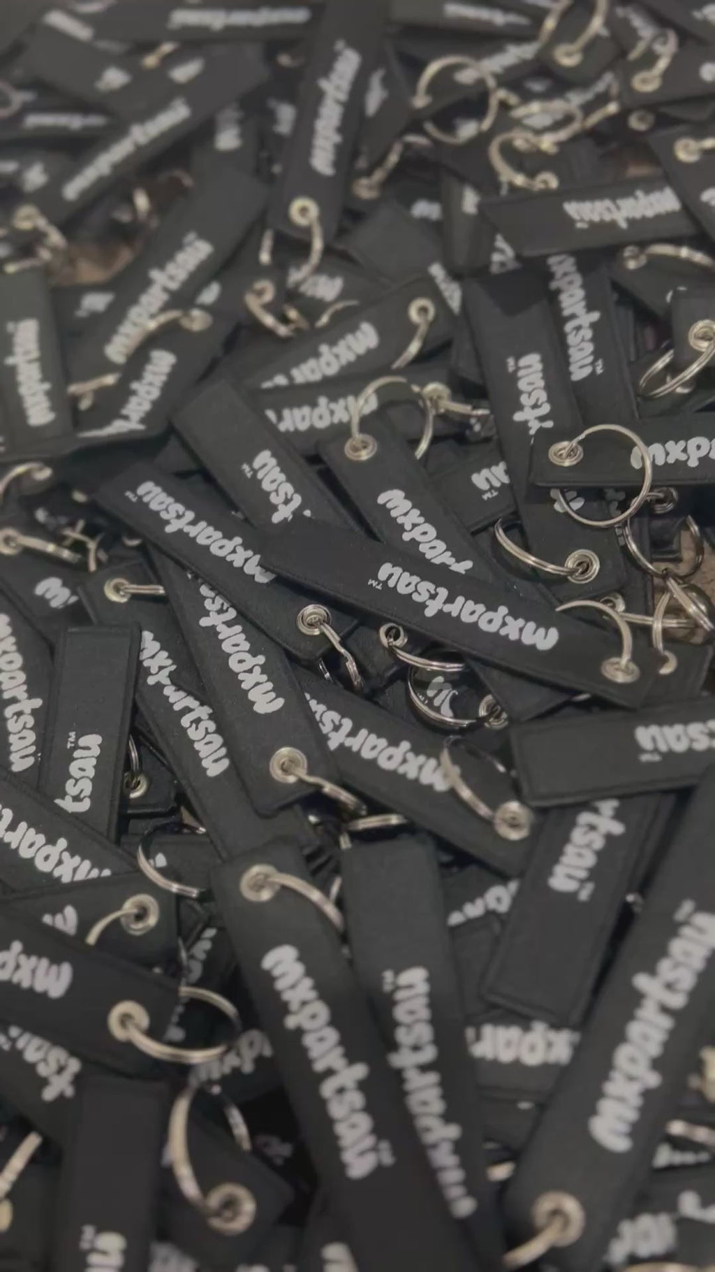 MXPartsAU rubber keychains in black with white branding, shown in a pile